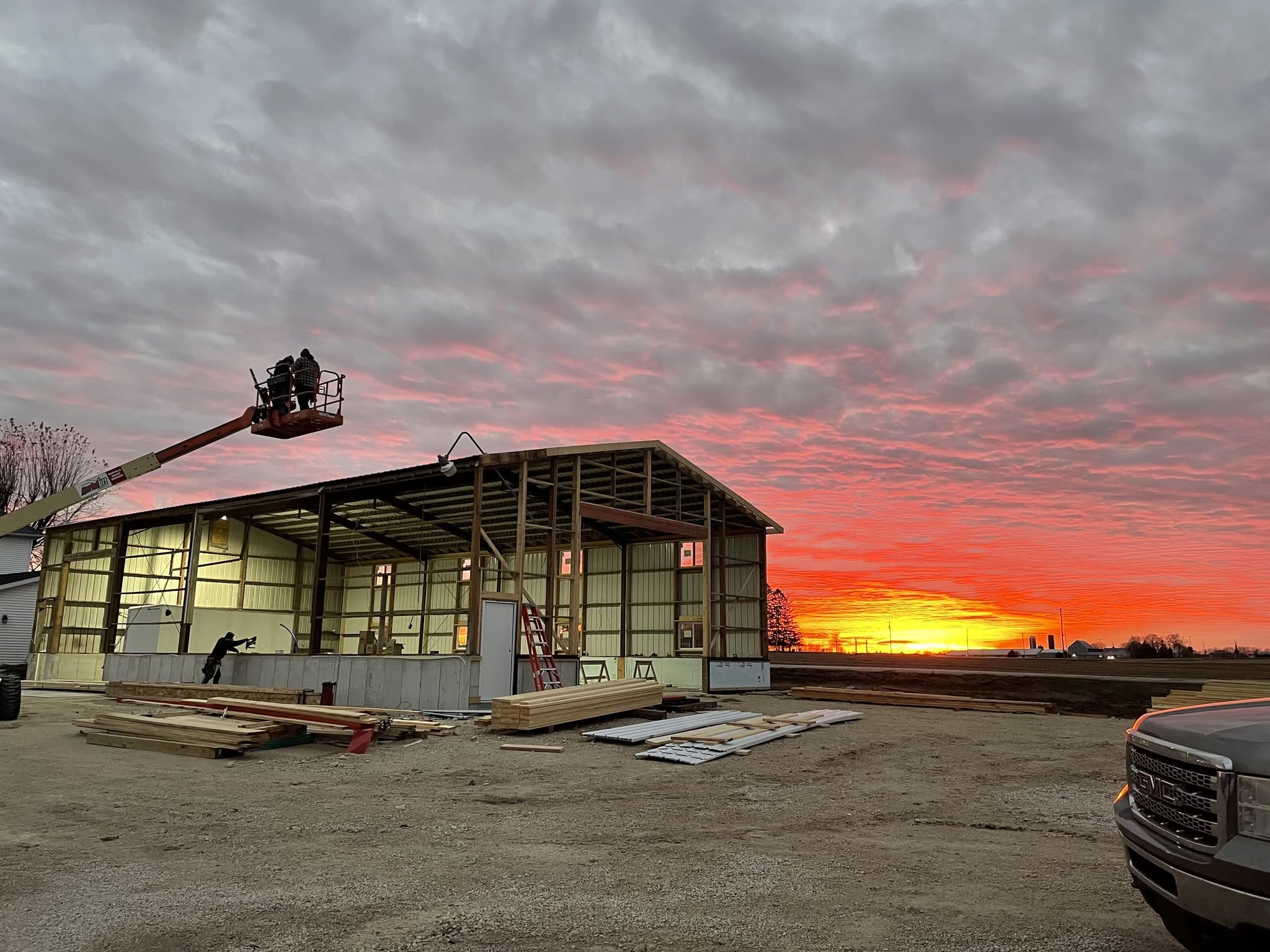 Commercial steel building under construction at sunset